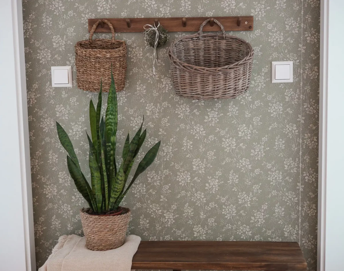 Garderobe mit Körben und geblümter Tapete